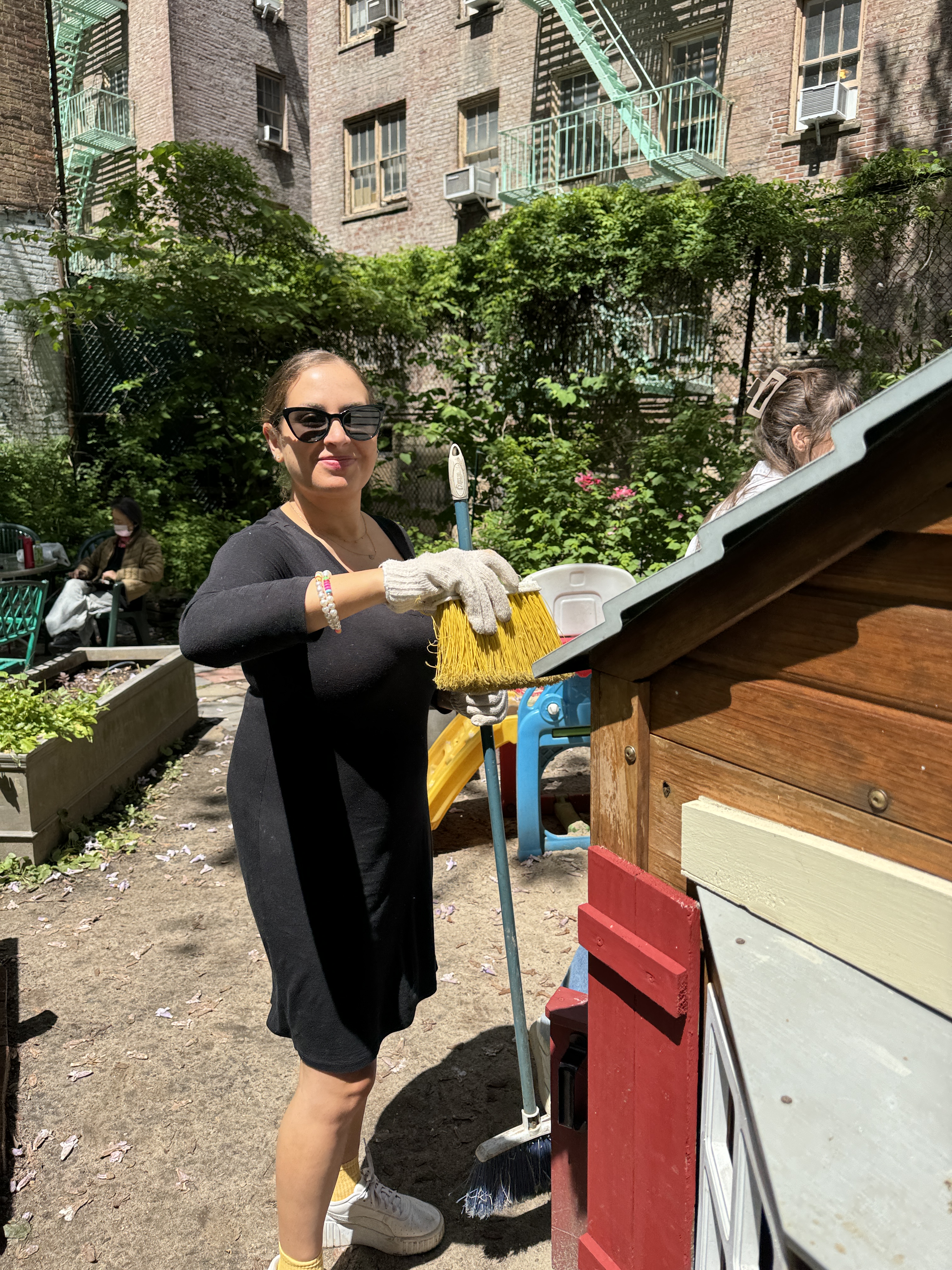 A volunteer cleaning the playhouse in the Garden.
